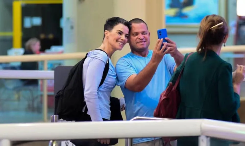 Sem passar despercebida, Ana Paula Arósio é clicada em aeroporto e atende pedido de foto com fã